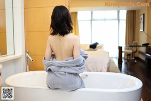 A woman sitting in a bathtub with her legs crossed.