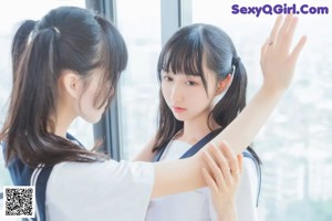 two asian girls in school uniforms posing for the camera