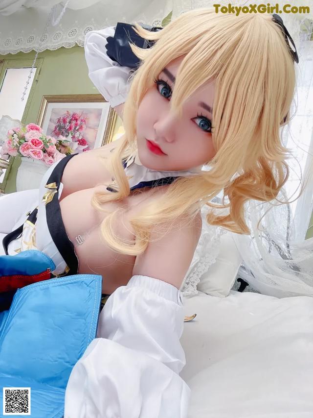 A woman in a maid outfit laying on a bed.