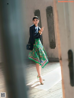 A woman in a brown suit holding a brown bag.