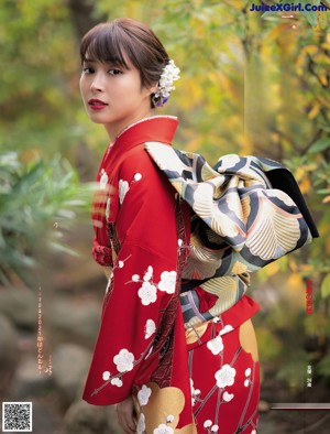 A woman in a red kimono is posing for a picture.