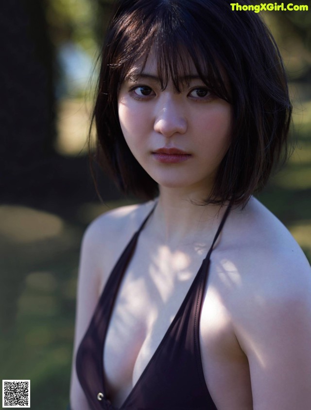 A woman in a black bathing suit posing for a picture.