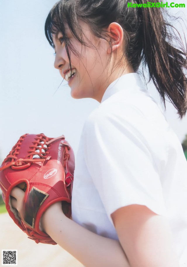 A woman in a white shirt holding a red baseball glove.