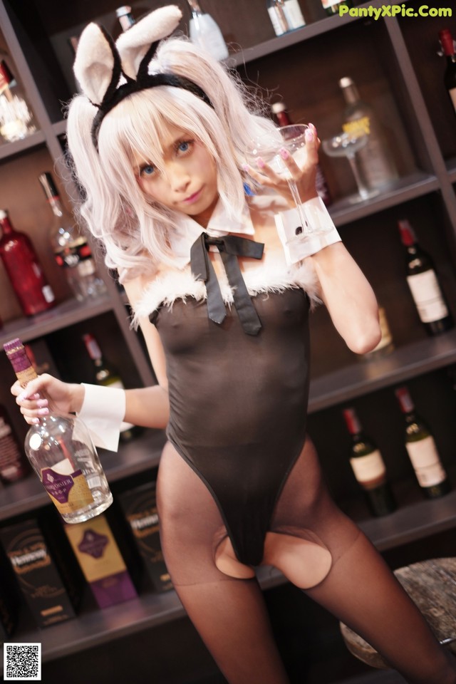 A woman in a bunny costume holding a glass of wine.