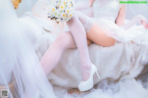 A woman in a white dress and cat ears posing for a picture.