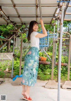 A woman in a white tank top posing for a picture.