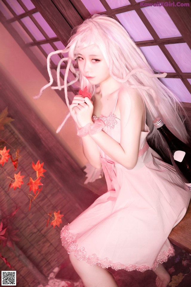 A woman in a pink dress holding a bottle of wine.