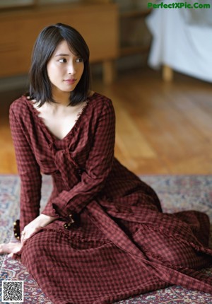 A woman leaning against a door in a room.