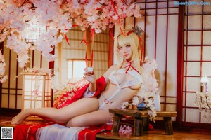 A woman in a red and white dress sitting on a wooden bench.