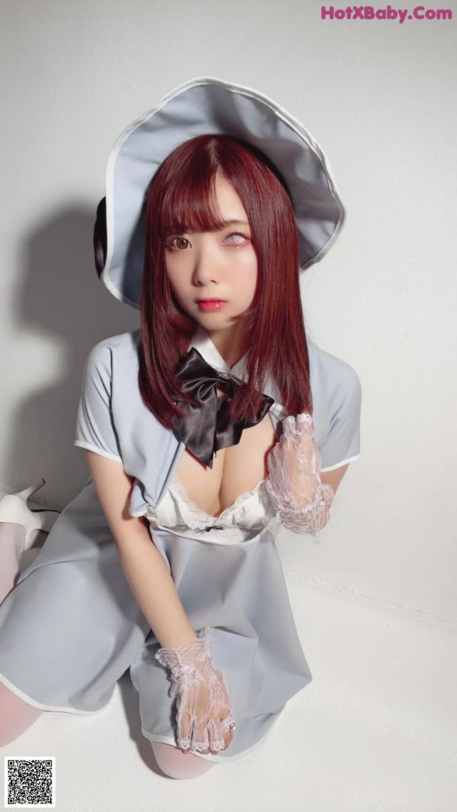 A woman in a maid outfit is posing for a picture.