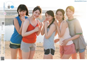 A group of young women standing next to each other on a beach.