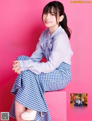 A woman in a blue and white checkered skirt posing for a picture.