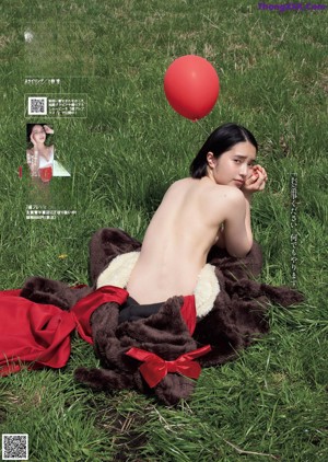 a woman in a white bikini laying on the ground covered in mud