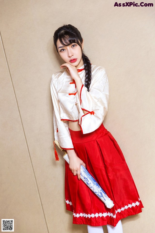 A woman in a red and white dress holding a sword.