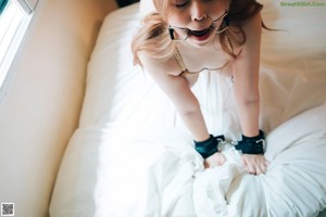 A woman is tied up and tied up on a bed.