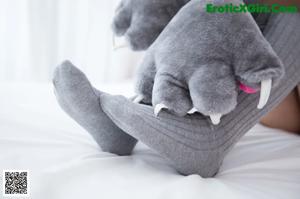 A woman in a cat costume sitting on a bed.