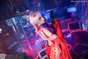 A woman in a red dress holding a gun.