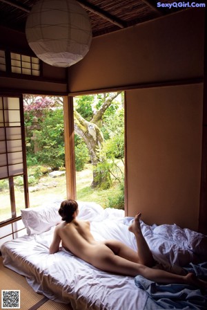 A woman in a white shirt and blue skirt laying on the floor.