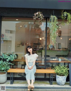 A woman in a green dress is posing for a magazine.