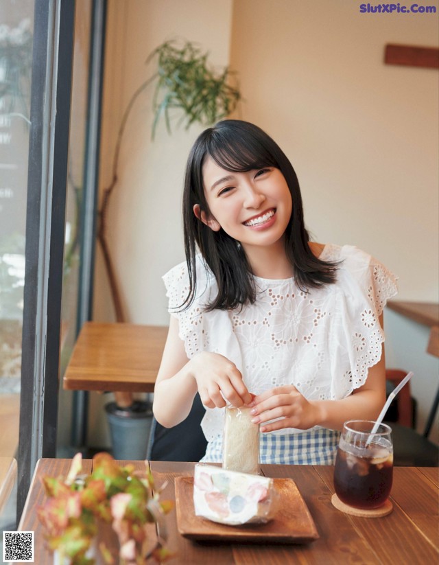 A woman sitting at a table with a plate of food.
