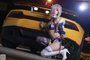 A woman standing next to a yellow sports car.