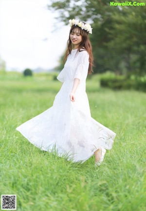 A woman with long brown hair and a white shirt.