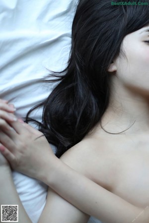 A woman in white stockings is sitting on a bed.