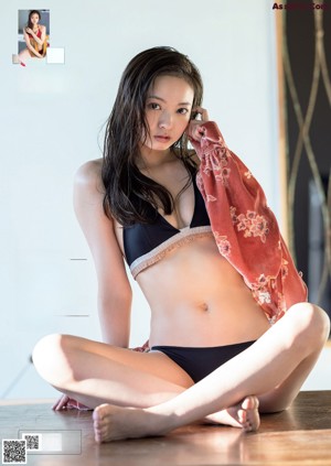 A woman in a red bikini sitting on a wooden chair.