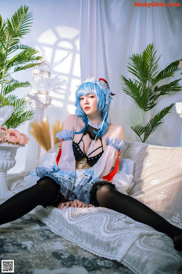 A woman with blue hair sitting on a couch.