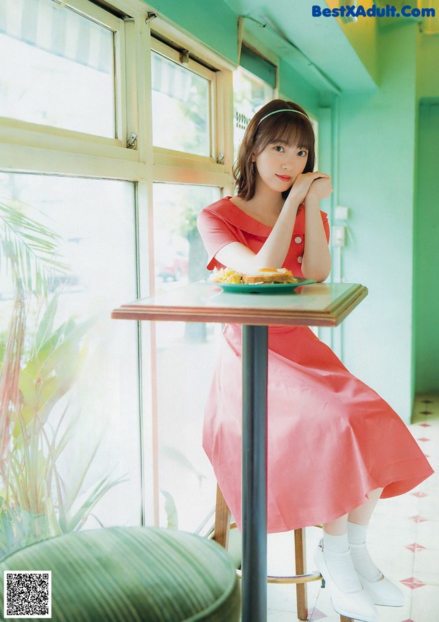 A woman sitting at a table with a plate of food.