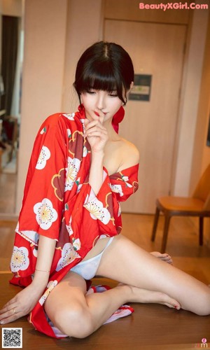 a woman in a red kimono sitting on a bed