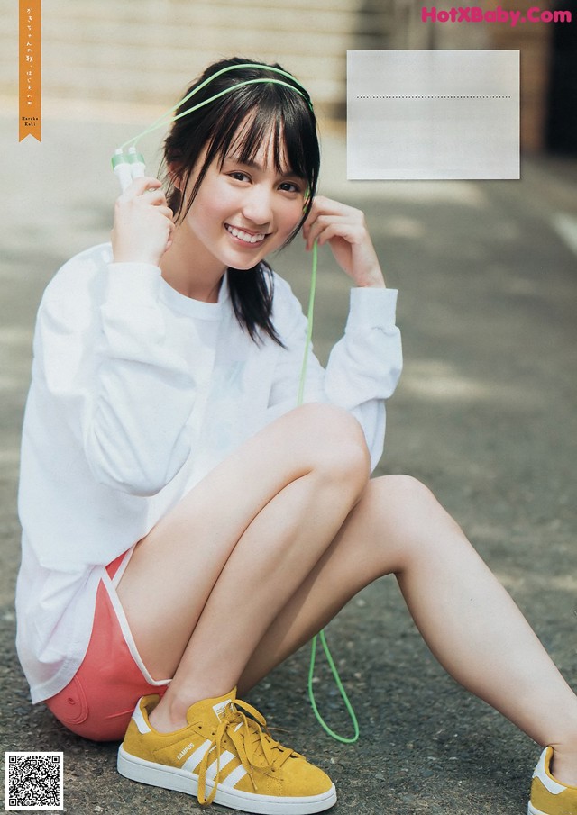 A woman sitting on the ground with her legs crossed.