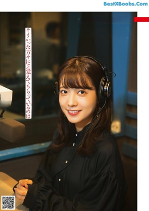A woman wearing headphones sitting at a table.