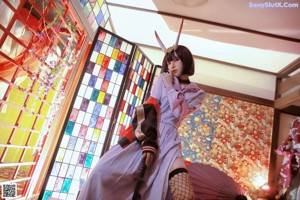 A woman in a kimono holding a red umbrella.