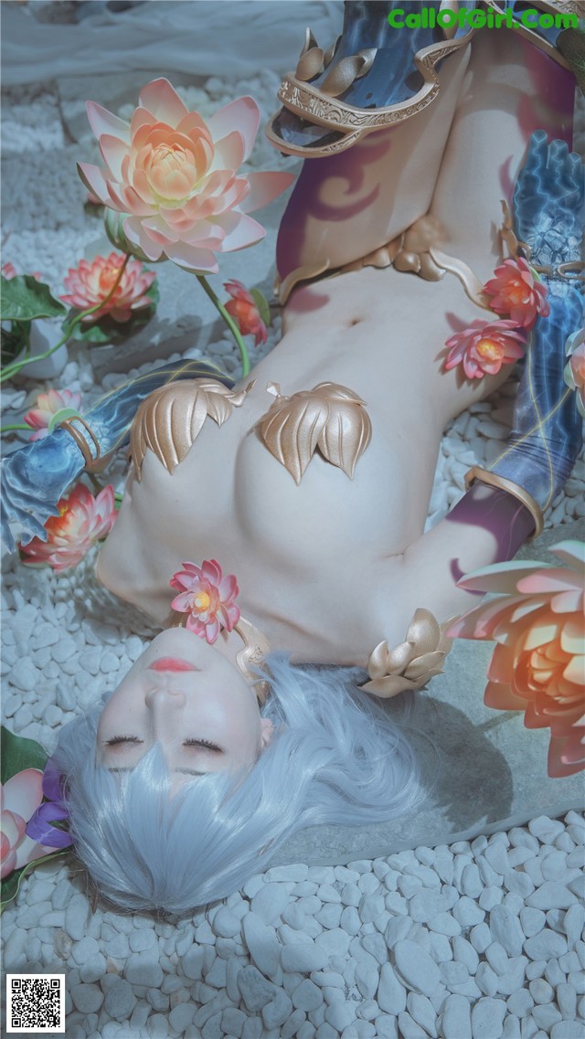 A woman laying on the ground surrounded by flowers.