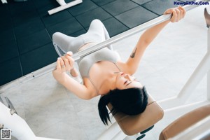 A woman sitting on a bench in a gym.