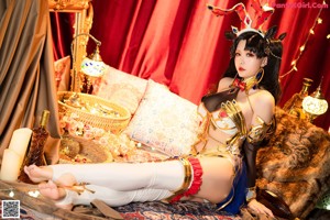 A woman in a costume sitting on a bed.