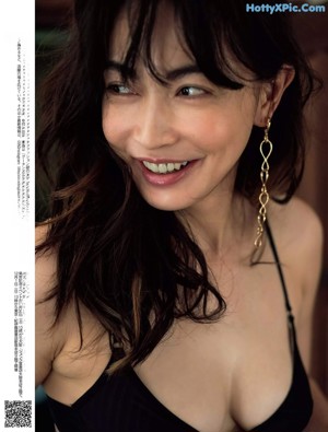 A woman in a black and white bra is looking up at the sky.
