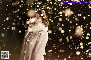 A woman in a white bikini and a white scarf.