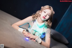 A woman sitting on top of a couch next to a green light.