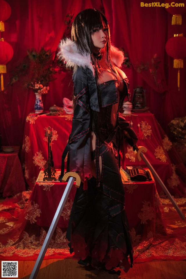 A woman in a black and red outfit holding a sword.