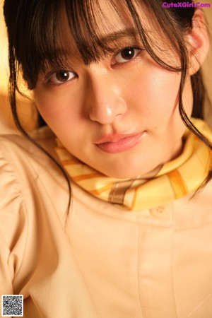A woman laying on top of a bed wearing a yellow scarf.
